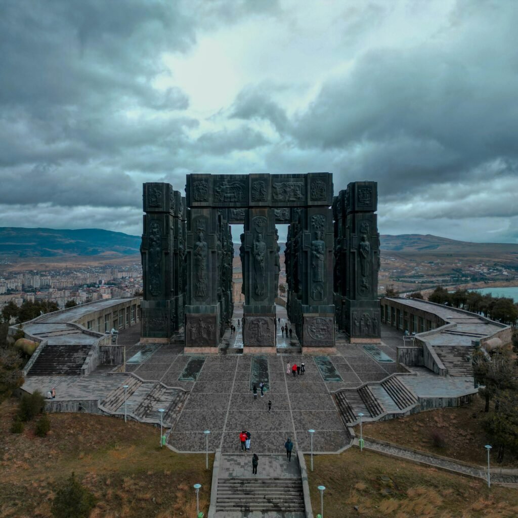 A stunning aerial shot of the Chronicles of Georgia monument with dramatic clouds.